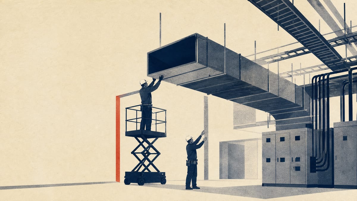 Workers installing large air-conditioning ducts and electrical cable trays inside an unfinished data-center building.