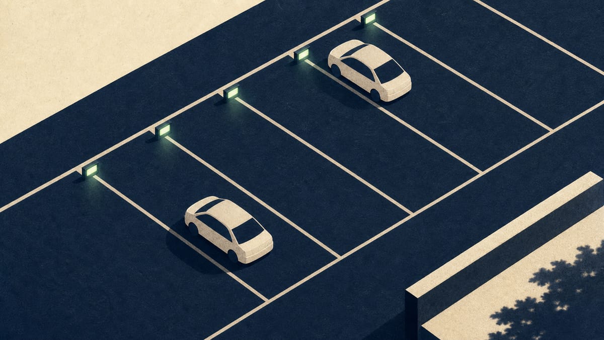 Aerial view of a parking lot grid with a few spaces marked by small indicator lights showing reserved and available status.