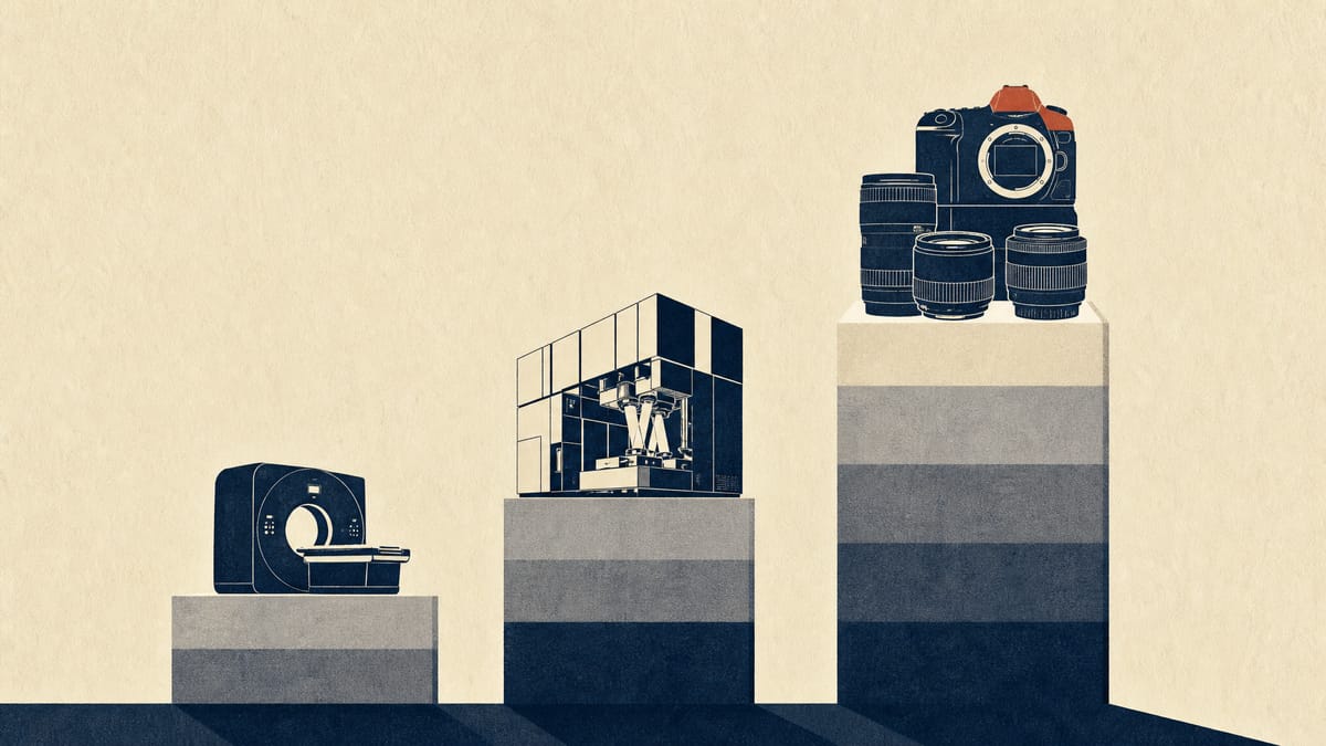Camera bodies and lenses on a production line next to an industrial lithography module and a medical scanner, arranged as stacks of differing height.